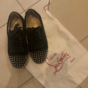 Svarta loubs med nitar - Snygga svarta sneakers från Christian Louboutin med nitar på tån. De är sparsamt använda och i fint skick! Säljes då det inte kommer till så stor användning☺️Köptes för 3000kr