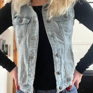 Ljusblå jeansväst - Säljer en snygg ljusblå jeansväst med knappar framtill. Perfekt för att ge din outfit en cool touch. Storlek Small 💗