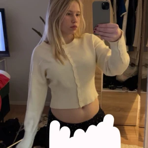 Vit ribbad kofta - Säljer en stilren vit kofta med knappar framtill. Den är croppad och har långa ärmar, perfekt för en trendig look. Koftan är ribbad vilket ger en snygg textur och passform. Inga defekter och inte mycket använd alls. Skriv gärna vid frågor🩷 