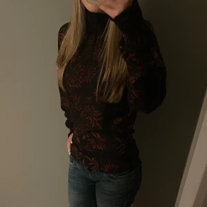 Svart och röd blommig polotröja - Snygg och unik festtopp med röda blommönster. Tröjan är polo🌺🥂