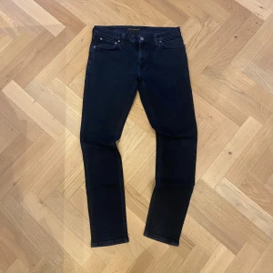Navy jeans från Nudie Jeans - Helt nya nudie jeans i en navy färg som sitter slim. Med en unik text på insidan av vänster fickan. Skriv om ni har några frågor. 