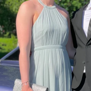 Ljusblå balklänning med pärldetaljer - Säljer nu min superfina balklänning med öppen rygg och strassdetaljer. Använd men i bra skick. Färgen är mest rättvis på första bilderna😊Jag är 180 lång och på mig är den till fötterna så perfekt om man är lite längre.