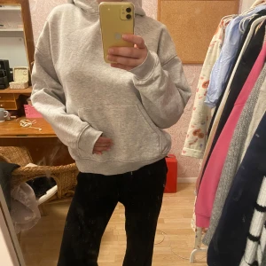 Grå hoodie från Gina tricot  - Säljer en klassisk grå hoodie från Gina tricot i storlek M. Den har en bekväm passform med en stor ficka framtill och en mysig huva. Den har inga defekter men är välanvänd 