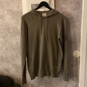 Ull hoodie från Scalpers - Säljer en stilren olivgrön hoodie från Scalpers i storlek S. Tröjan har en klassisk design med huva, samt ett diskret broderat märke på framsidan. Perfekt för en avslappnad stil. Nypris runt 2000, riktigt skön och extremt snyggt plagg. Välsigt bra skick 