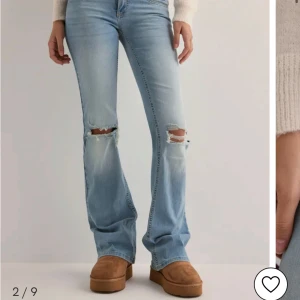 Ljusblå bootcut jeans med slitningar - Snygga ljusblå jeans med bootcut-stil och slitningar på knäna. De har blivit lite större i hållen än när de köptes annars är de inget ändrat! Super bra skick använt fåtal gånger