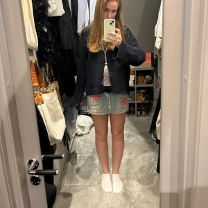 Jeanskjol med rosa detaljer - Trendig jeanskjol i ljusblå denim från DIESL med slitna kanter och rosa detaljer på fickorna. Kjolen har en kort längd och är perfekt för en avslappnad stil. Den har en klassisk femficksdesign och bälteshällor. (Krånglig dragkedja)