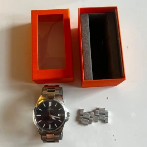 Mörkblå Morris klocka ⏰  - Snygg och stilren klocka från Morris med en silverfärgad länkarmband och mörk blå urtavla. Klockan har tydliga markeringar och en robust design som passar perfekt för den som gillar klassisk stil. Perfekt accessoar för att lyfta din look. Ny pris 2 795kr.