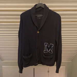 Morris Ivy League Cardigan - Tjena! Säljer denna klockrena cardigan från Morris. Inga skador eller slitningar och använd ett fåtal gånger. Har en stilig M-detalj vid den vänstra fickan! Kontakta gärna om du har frågor eller vill se mer detaljer. Priset är såklart diskuterbart. Vi hörs! 🙌