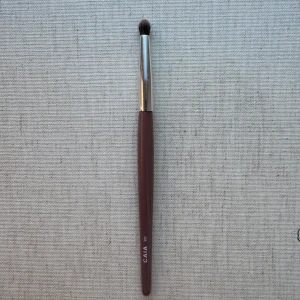 Ögonskuggsborste från CAIA - Säljer en ögonskuggsborste från CAIA. Perfekt för att applicera och blanda ögonskugga. Borsten är kompakt och rundad för enkel användning. 