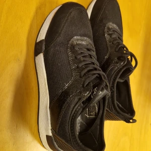 Svarta sneakers från Tom Tailor - Snygga svarta sneakers från Tom Tailor med memory effect för extra komfort. Skorna har en vit sula och klassisk snörning. Perfekta för en stilren look.