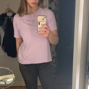 Ljuslila t-shirt med spetsdetalj - SUPER SÖT ljuslila t-shirt med korta ärmar och en vacker spetsdetalj runt halsringningen. Storlek S/M