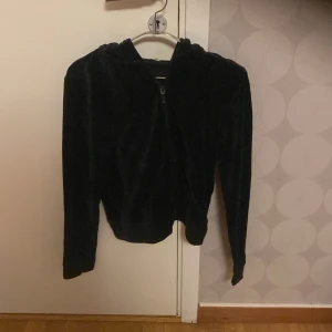 Svart hoodie med dragkedja - Säljer en svart hoodie med dragkedja. Den har en mysig huva och långa ärmar, perfekt för kyliga dagar. 