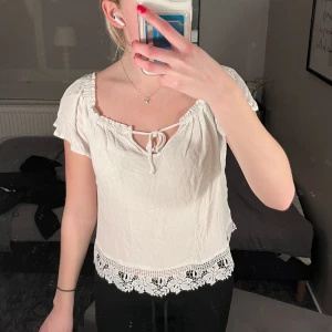 Vit blus med spetsdetaljer - söt vit blus med korta ärmar, spetsdetaljer nedtill och knytning framtill! Skriv om ni har frågor. Jag har vanligtvis XS/S i kläder och denna passar mig!