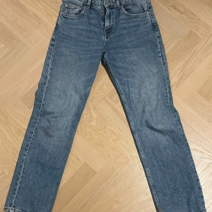 Blå jeans från Pull&Bear - Snygga blå jeans från Pull&Bear i klassisk design. De har en normal passform med dragkedja och knapp framtill. Perfekta för en avslappnad stil.