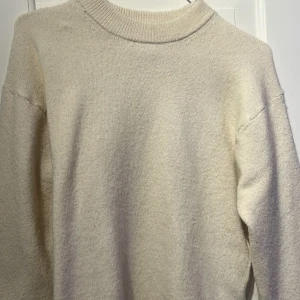 Beige stickad tröja från H&M - Mysig beige stickad tröja från H&M med rund halsringning. Perfekt för kyliga dagar och enkel att matcha med olika outfits.