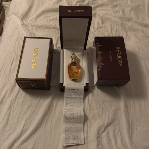 Xerjoff La Capitale Parfym 50ml - Elegant parfym från Xerjoff, La Capitale, i en lyxig flaska med gulddetaljer. Kommer i en stilren mörkröd förpackning med guldtext. Perfekt för den som söker en exklusiv doftupplevelse. Den är köpt på NK för 2700 de är runt 40 ml kvar i flaskan 