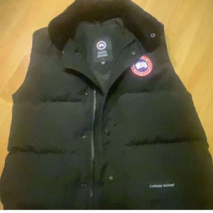 Svart dunväst från Canada Goose - Säljer en svart dunväst från Canada Goose då den inte blir till användning längre! Passar både tjej och kille.