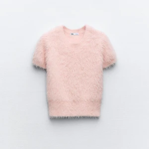Rosa fluffig tröja från Zara - Säljer en supermjuk och fluffig rosa tröja från Zara. Den har korta ärmar och en rund halsringning, perfekt för en mysig look. Tröjan är i en härlig pastellfärg som ger en söt och trendig stil. Aldrig använd. Prislapp kvar 