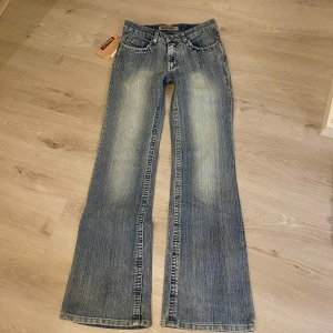 Blå bootcut jeans med strassdetaljer - Snygga blå bootcut jeans med coola strassdetaljer på bakfickorna. Perfekta för att ge din outfit lite extra bling. Helt oanvända!💗