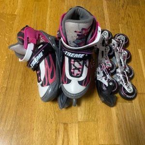 2 in 1 Skridskor & rullskridskor  - Säljer ett par justerbara inlines från Biltema i grått och rosa med svarta detaljer. De har en cool flammig design och är utrustade med snörning och spännen för extra säkerhet. Perfekta för en rolig åktur!