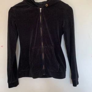 Hoodie  - Svart hoodie i gosigt material. Den går in vid midjan. 