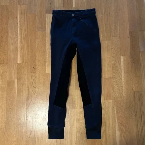 Svarta ridbyxor - Svarta ridbyxor från Covalliero. Mått från linningen ner till foten på sidan 85 cm. Midja 60 cm. Lite resår. En ficka fram. 
