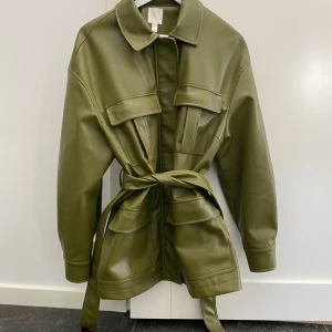 Grön Jacka - Grön jacka med knyte i midjan (går att ta bort) / Dragkedja & Knappar finns också / Strl L (har använt som oversized, är själv S-M) / Fint skick! 