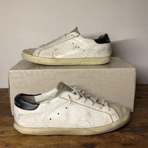 Golden Goose skor - Säljer dessa snygga Golden Goose. Skorna är i storlek 40 men passar mer 41. Originalbox ingår. Snörena är inte original. Ena hälen är lite nedtrampad och sliten vilket syns på tredje bilden. Skriv om du har någon fråga eller prisförslag!