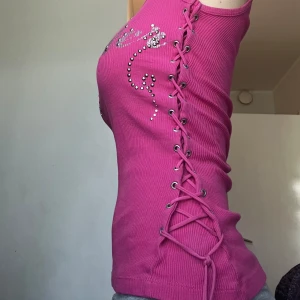 2000s linne med snörning  - Rosa coolt linne med snörning på sidorna från fishbone⭐️Står XS i tröjan men passar lika bra på S 