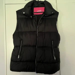 Dunväst JXELLIE - Dunväst från Nelly. Använd fåtal gånger och är i fint skick. Köpt för 400kr. Storlek M men passar en S också.
