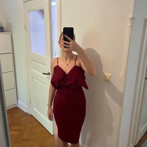 Vinröd festklänning - Mycket fin festklänning som jag använt bara en gång, man kan bära den pa tre olika sätt sa som jag visar uppe pa bilderna 🌸 , bältet medföljer Den har inget märke då den var sydd hos en skräddare strl. S, sitter tight på kroppen, använd bara en gång