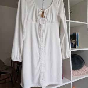 Långärmad vit klänning - Beställd från sellpy, passade inte i storlek. Fick den i bra skick. Lite tjockare geno.skinligt material. Ca 80 cm