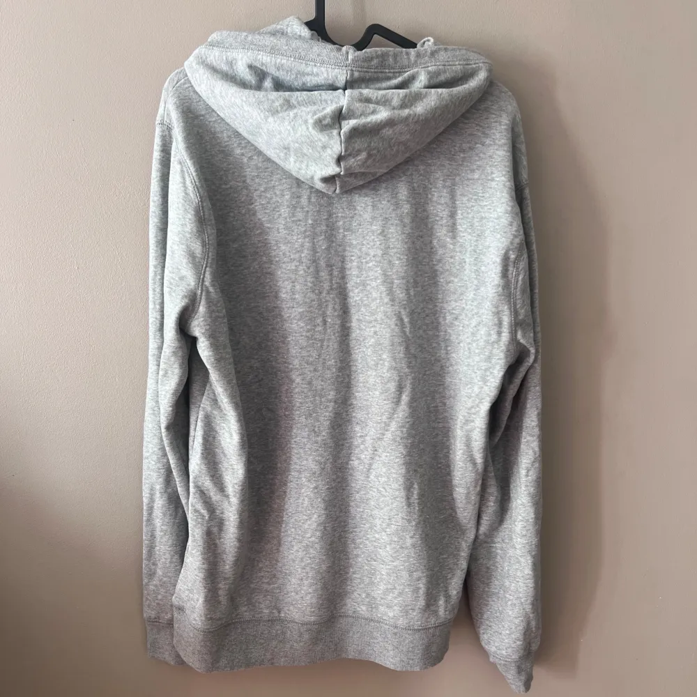 Säljer en snygg och bekväm grå hoodie från Original Penguin. Den har en klassisk design med en känguruficka och justerbar dragsko i huvan. Perfekt för en avslappnad stil och passar till alla tillfällen. Tillverkad i Bangladesh.. Tröjor & Koftor.