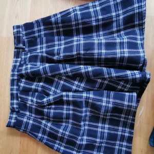 Kort svart/vitrutig kjol stl M - Svart/vitrutig kort kjol stl M  Med hällor för skärp, lite vidare modell i kjolen 