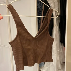 Topp - Mycket kort brun topp från NA-KD. mycket stretchig. 