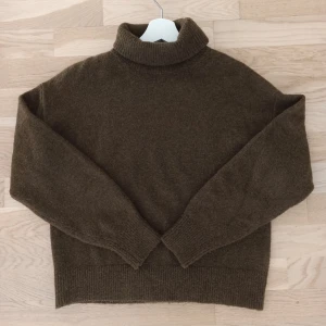 Brun polotröja från H&M - Säljer en mysig mörkgrön  polotröja från H&M i storlek XS. Perfekt för höst och vinter med sin varma och bekväma design. Tröjan har långa ärmar och är tillverkad i ett mjukt material som håller dig varm under kyliga dagar.