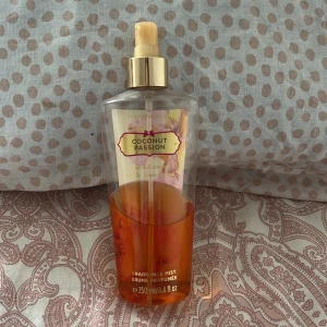 Coconut Passion Fragrance Mist - Säljer en fräsch och exotisk doftmist från Victoria's Secret, Coconut Passion. Den har en härlig blandning av vanilj och kokos, perfekt för en somrig känsla. Flaskan är genomskinlig med en gyllene spraypump. Dock är det bara 125 ml  kvar, typ halva!