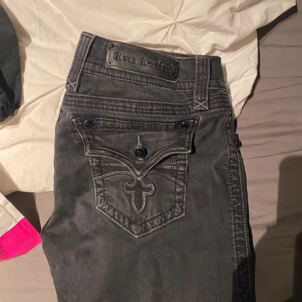 Säljer ett par grå bootcut jeans från Rock Revival. De har snygga detaljer med broderier på bakfickorna och knappar i metall. Jeansen är gråa🙏 Intressekoll, inte säker att jag vill sälja. Jeans & Byxor.