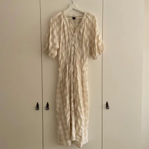 Rutig klänning - Rutig klänning i beige och vitt. Knappt använd då den är för stor för mig! 
