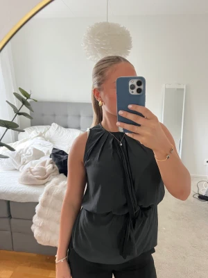 Blus - En söt mörkgrå blus som endast är använd 1 gång. Har en knytgrej där fram. 