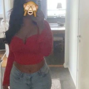 Röd långärmad topp - Säljer en snygg röd långärmad topp med en v-ringad design och rynkade detaljer vid bysten. Perfekt för en utekväll eller fest. Toppen är i ett mjukt och bekvämt material.