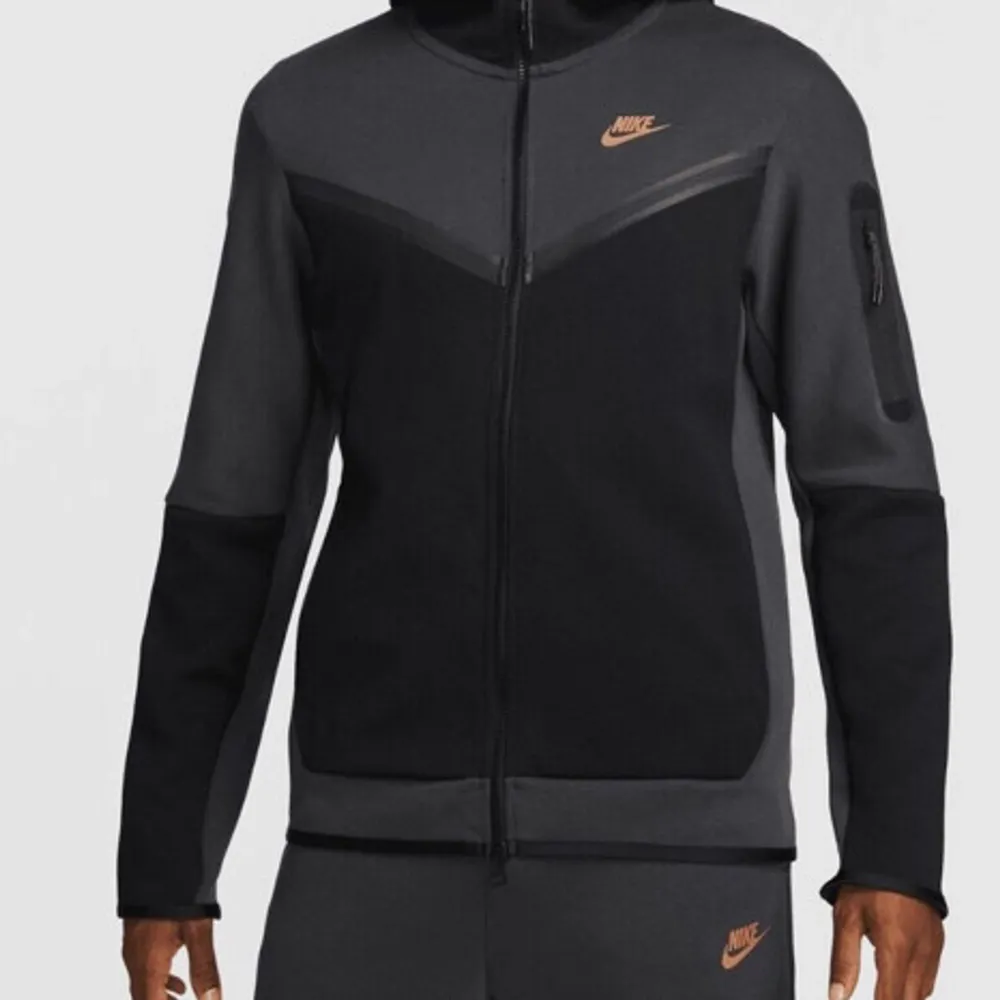 Säljer en snygg svart och grå Nike tech fleece Den har en dragkedja framtill och en huva för extra komfort. Perfekt för träning eller vardagsbruk. Zipen har en cool design med Nike-loggan i guld på bröstet och ärmen.  Pris kan diskuteras. . Hoodies.