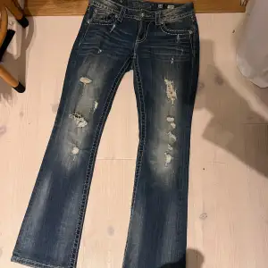 Säljer mina snygga blå jeans från Miss Me i storlek 28 som tyvärr blivit försmå. De har en låg midja och är utsvängda i benen (modellen är boot som ni kan se på bilden) De har coola slitningar och broderade detaljer på bakfickorna med lite bling bling. Midjemåttet är 39cm tvärs över och innerbenslängden är 80cm ❤️