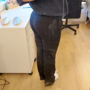 Svarta kostymbyxor från Bik Bok, low waist, vera - Säljer ett par svarta kostymbyxor från Bik Bok i storlek 36. Modell vera, low waist. Nypris 499. De har en klassisk design med normal passform, utsvängda ben och är perfekta för både vardag och fest. Byxorna har fickor och stängs med dragkedja och knapp. Superbekväma och stilrena!