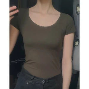 Stretchig t-shirt militärgrön S - Nyskick, oanvänd. Osäker på storlek, troligen S eller XS. 90% bomull, 5% elastan. Vidd: 33-38, längd: 57.