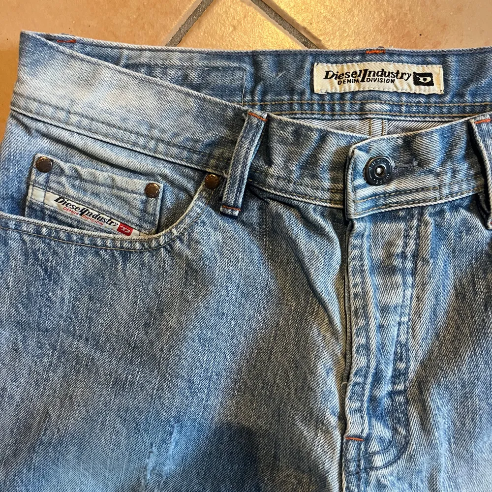 Säljer ett par ljusblå vintagejeans från Diesel i bra skick. Har några små slitage, men det bidrar bara till vintage-känslan. De har en klassisk femficksdesign med full button fly. Jeansen har en relaxed passform och är perfekta för en avslappnad stil. Size on tag är 32, funkar bra för ca W31 L32. Jeans & Byxor.