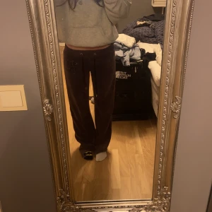 Lila mjukisbyxor från Juicy Couture - Säljer ett par low waist lila mjukisbyxor från Juicy Couture i storlek M. Vill notera att jag vanlig vis brukar ha S/XS och dessa passar perfekt så jag skulle säga att byxan liknar mer S än M.Byxorna är supermjuka och bekväma, de har även en söt detalj med en katt i rhinestones på sidan. 💗