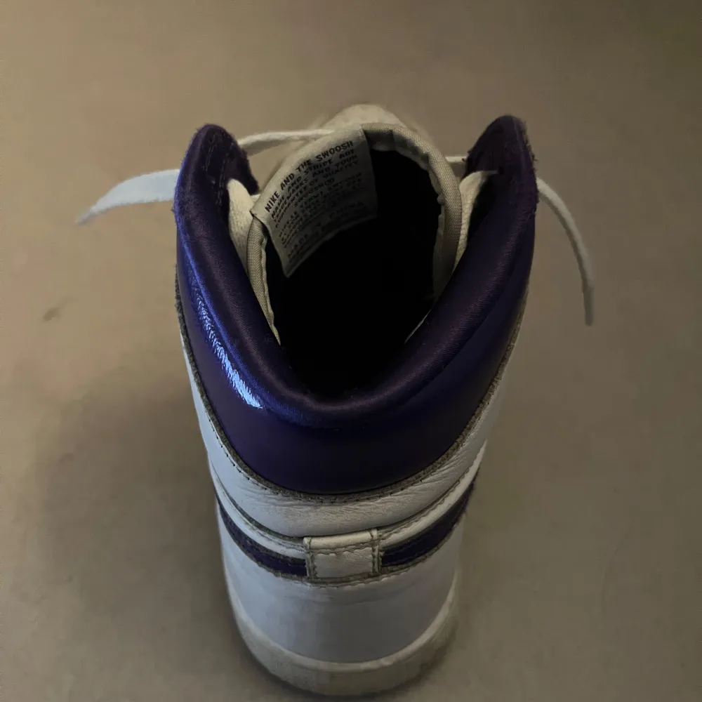 Säljer ett par klassiska Nike jordans sneakers i vitt med lila detaljer. Skorna har snörning och är i bra skick med lite slitage. Perfekta för både vardag och träning. De har en hög modell med bekväm passform. Pris kan diskuteras.. Skor.