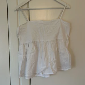 Vit linnetopp från Gina Tricot - Säljer en söt vit linnetopp från Gina Tricot i storlek L. Toppen har tunna axelband och en luftig passform, perfekt för varma sommardagar. Materialet är lätt och bekvämt, vilket gör den idealisk för både vardag och fest. Ett måste i sommargarderoben! 🌞