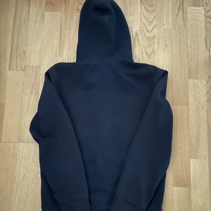 Mörk blå zip hoodie från Ralph Lauren - Säljer en stilren svart hoodie från Ralph Lauren med dragkedja och den klassiska loggan på bröstet. Perfekt för både vardag och chill. Den är i bra skick och superbekväm att ha på sig. Passar till allt och är ett måste i garderoben!